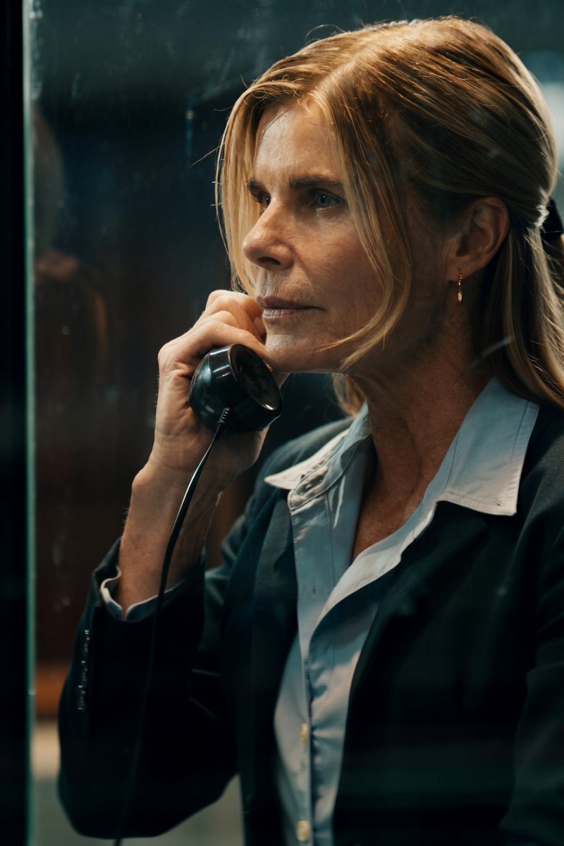 Mariel Hemingway as Ally Fremont, on the phone, in a dark suit