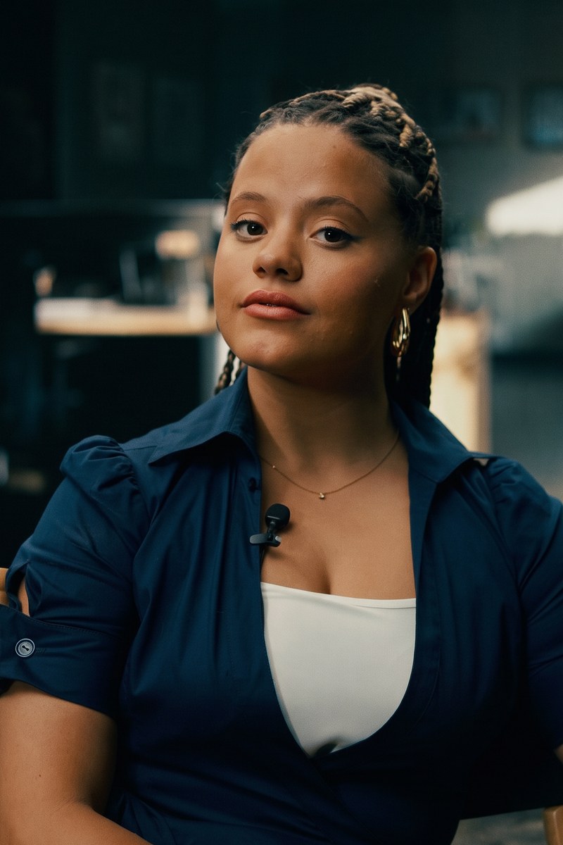 Sarah Jeffery as Ms. Heatherton, the prison counselor, with a slight smile